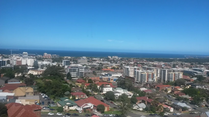 city with high rise buildings, and ocean in the distance