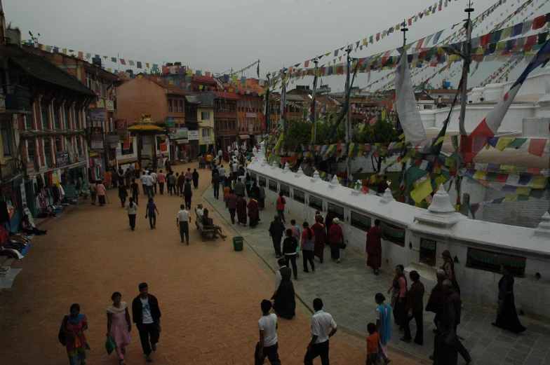 people are walking around a town square during the day