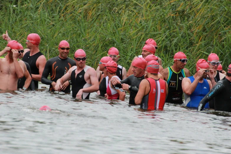 a crowd of swimmers in the water in full wet suits