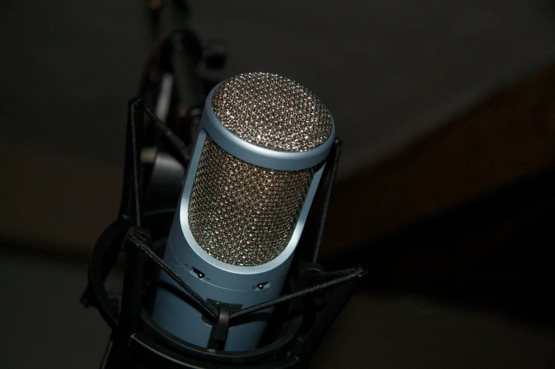 a blue and silver microphone sitting on top of a stand