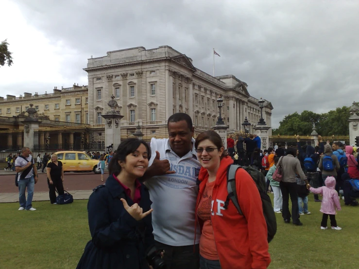 four people standing outside in front of a large building