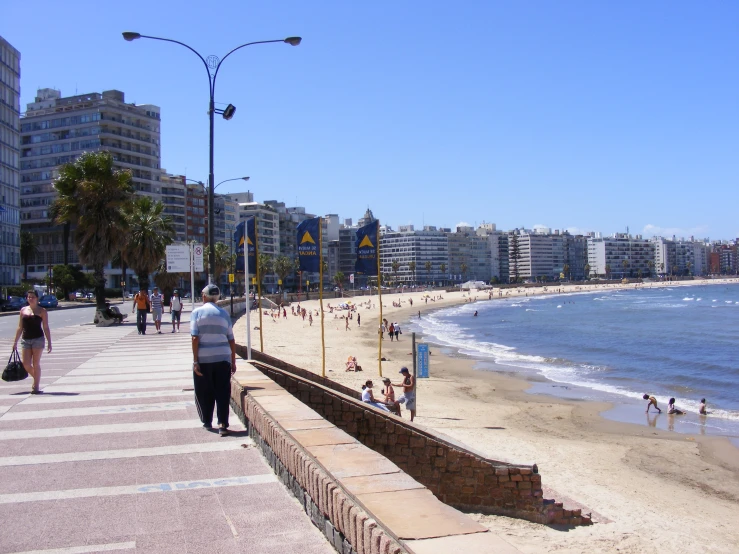 a beach filled with lots of people walking on the water