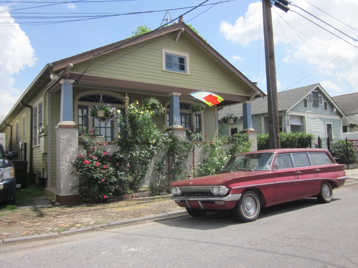 an old style red car parked on the side of a road