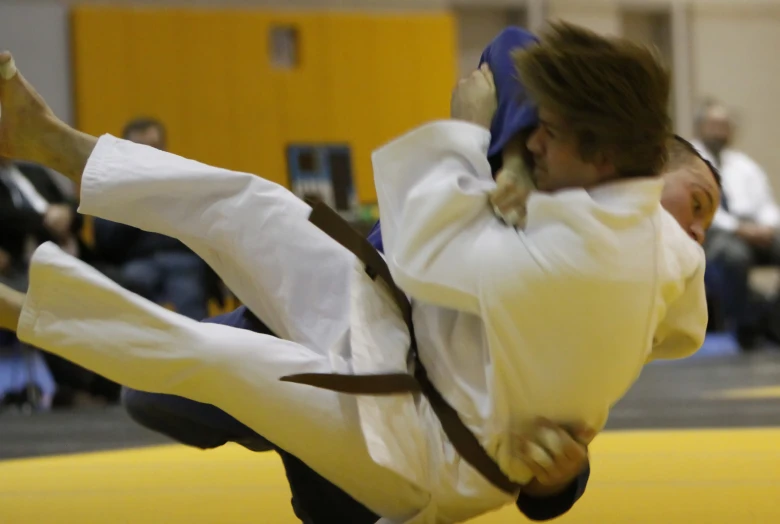a man on a yellow mat holding out his arm