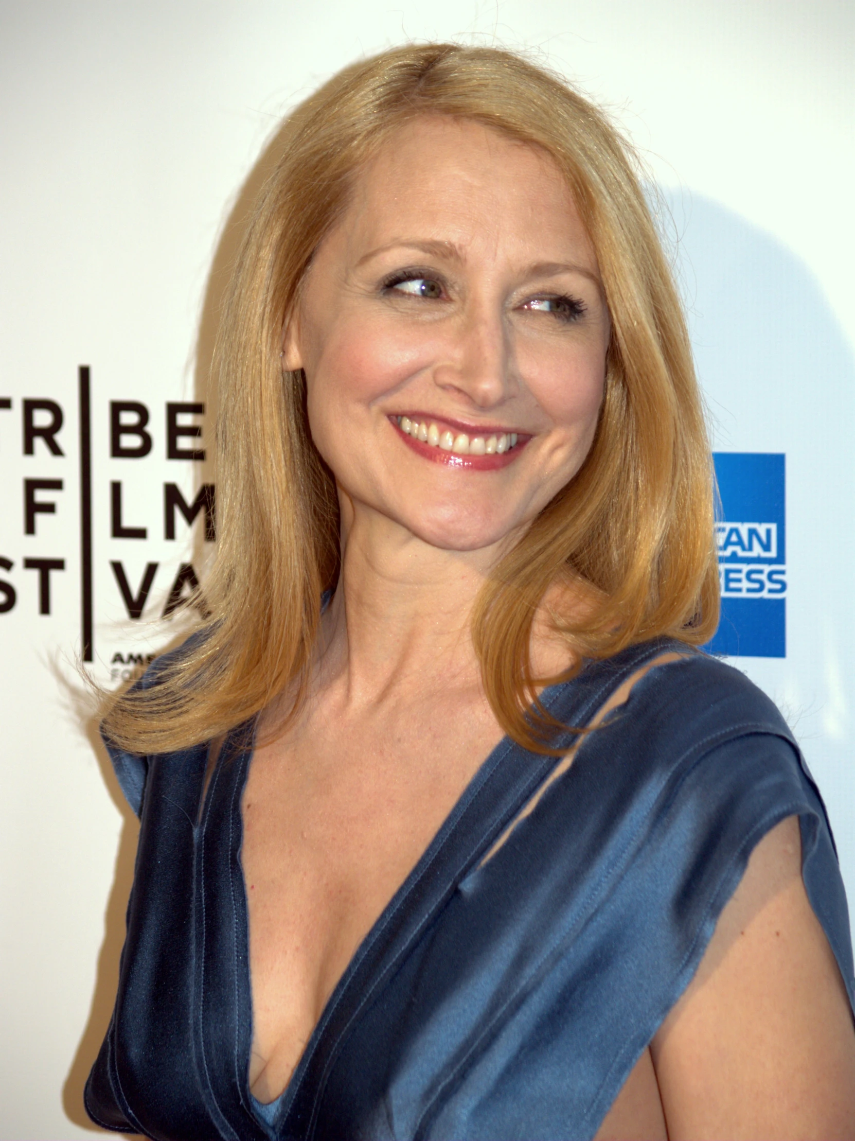 a woman with blonde hair and blue dress on posing for the camera