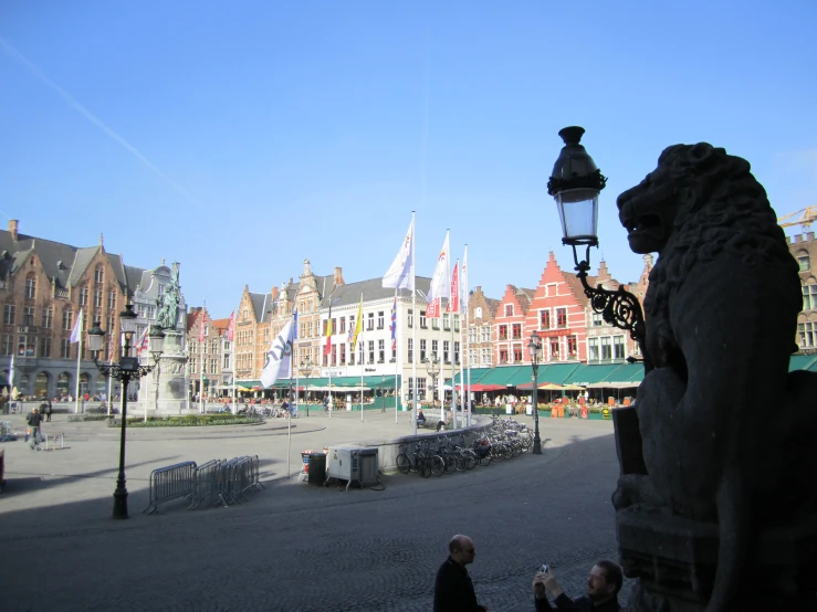 a stone statue with a light on it stands near a city street