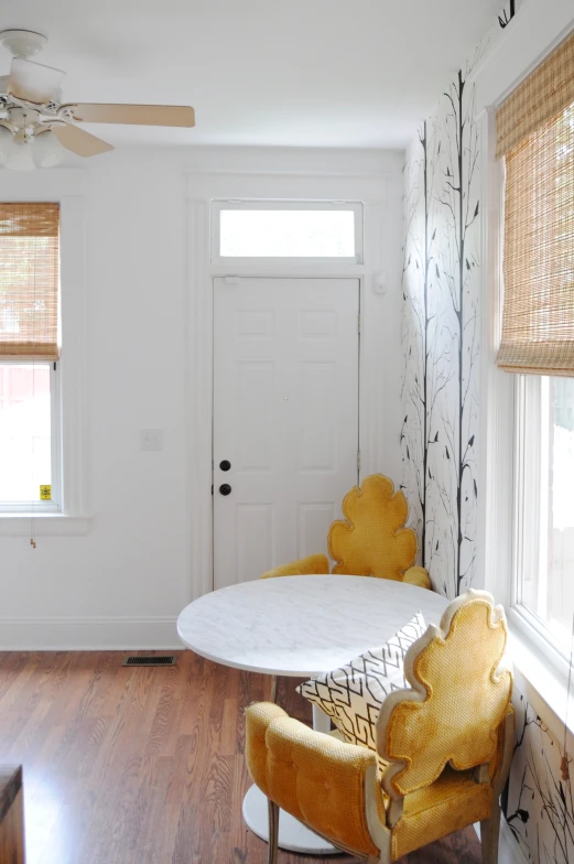 a chair sitting in front of a table with two yellow chairs on top