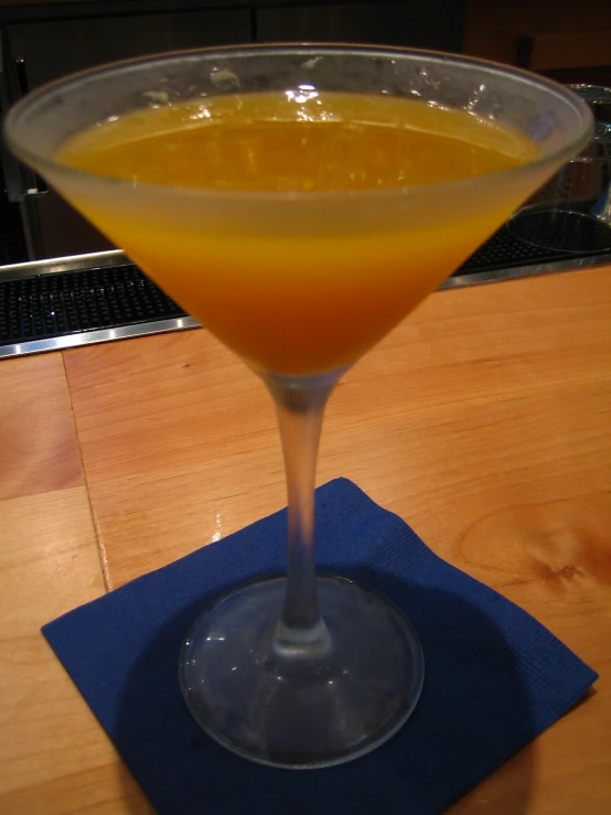 an orange drink sits in a martini glass