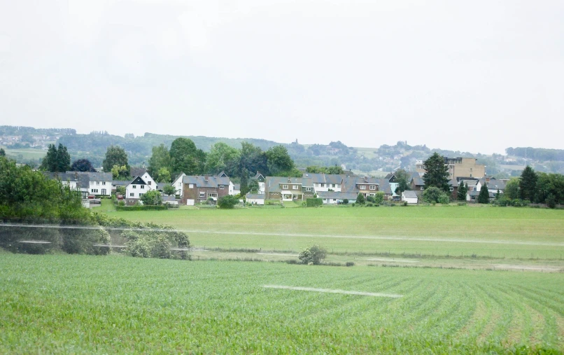 an agricultural field with lots of trees and houses on top