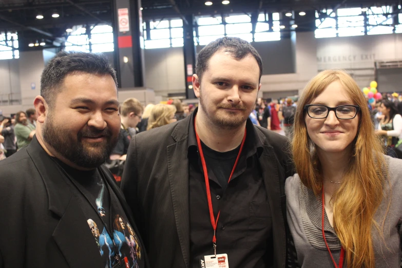 two men and a woman smile as they pose for a picture