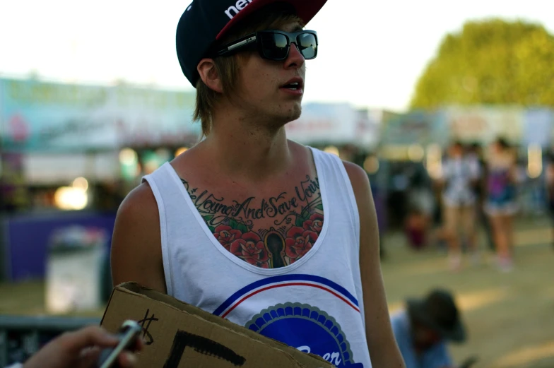 a man with tattoos on his chest wearing sunglasses