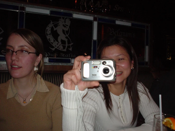 two women taking a picture in a mirror