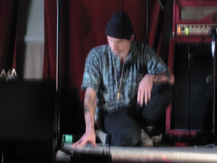 a man kneeling in front of some microphones