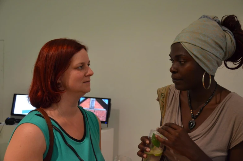 two beautiful women standing next to each other talking