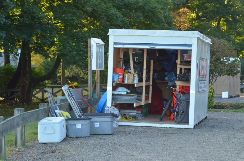 an outside shed filled with various items that is kept on the ground