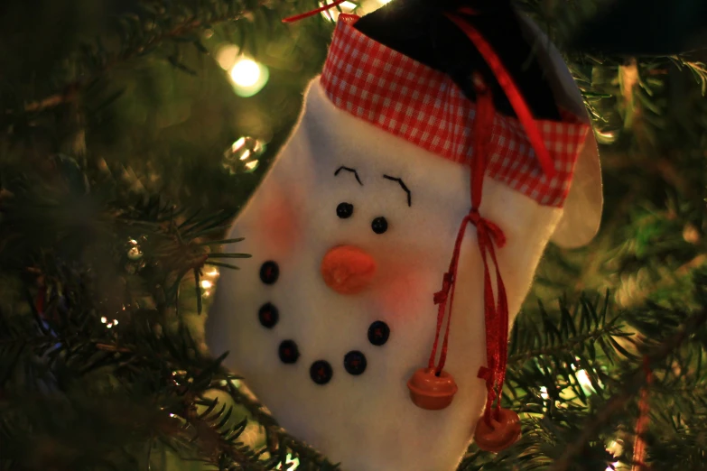 a snowman ornament hanging on a christmas tree
