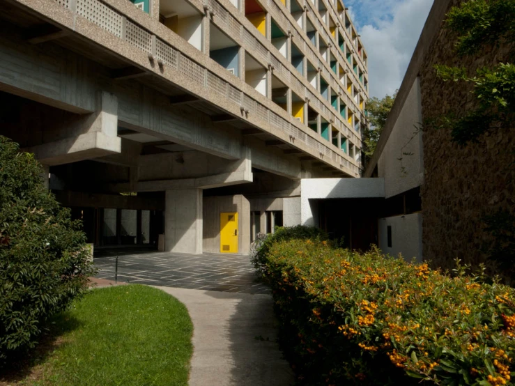 a building with lots of windows, flowers and greenery