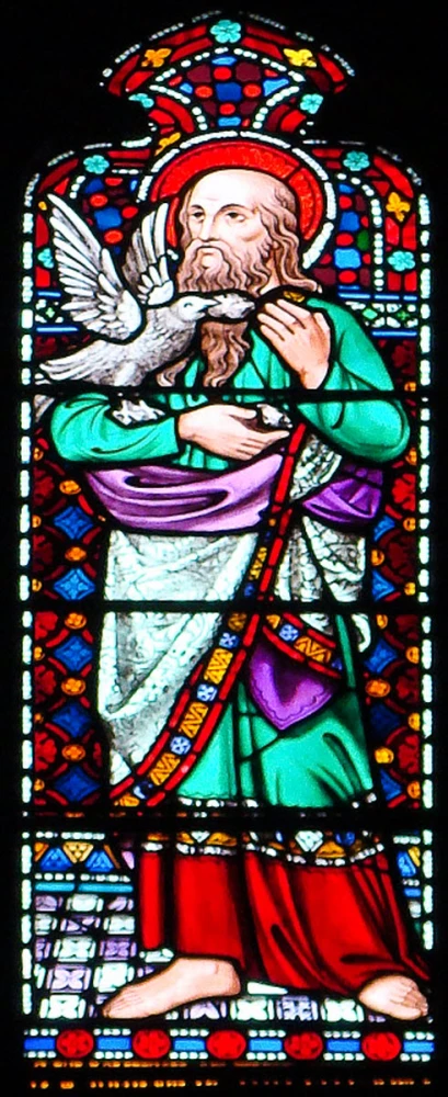 a stained glass window of jesus holding a dove