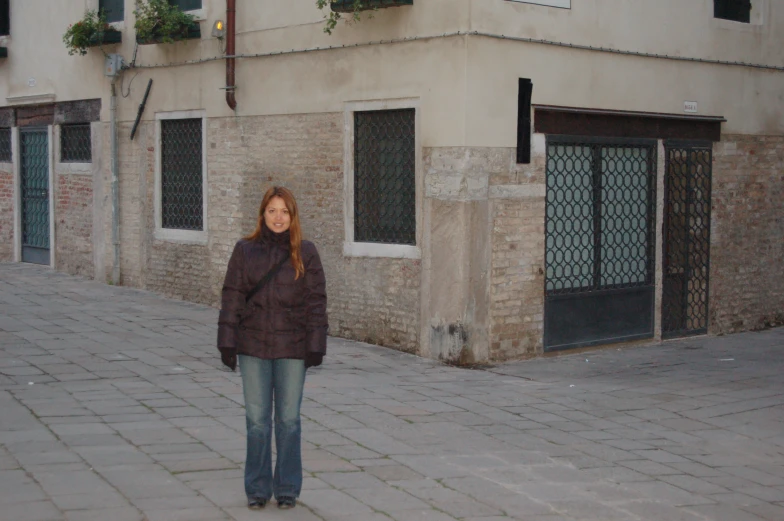 a person standing on a paved road next to a building