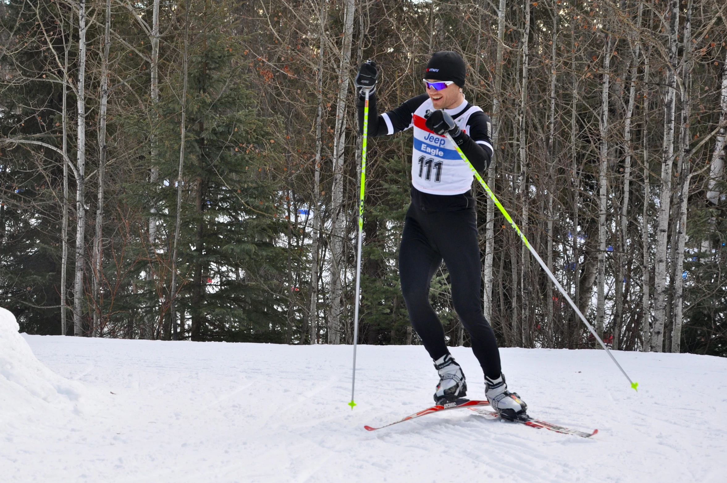 a male skier in the middle of cross country skiing