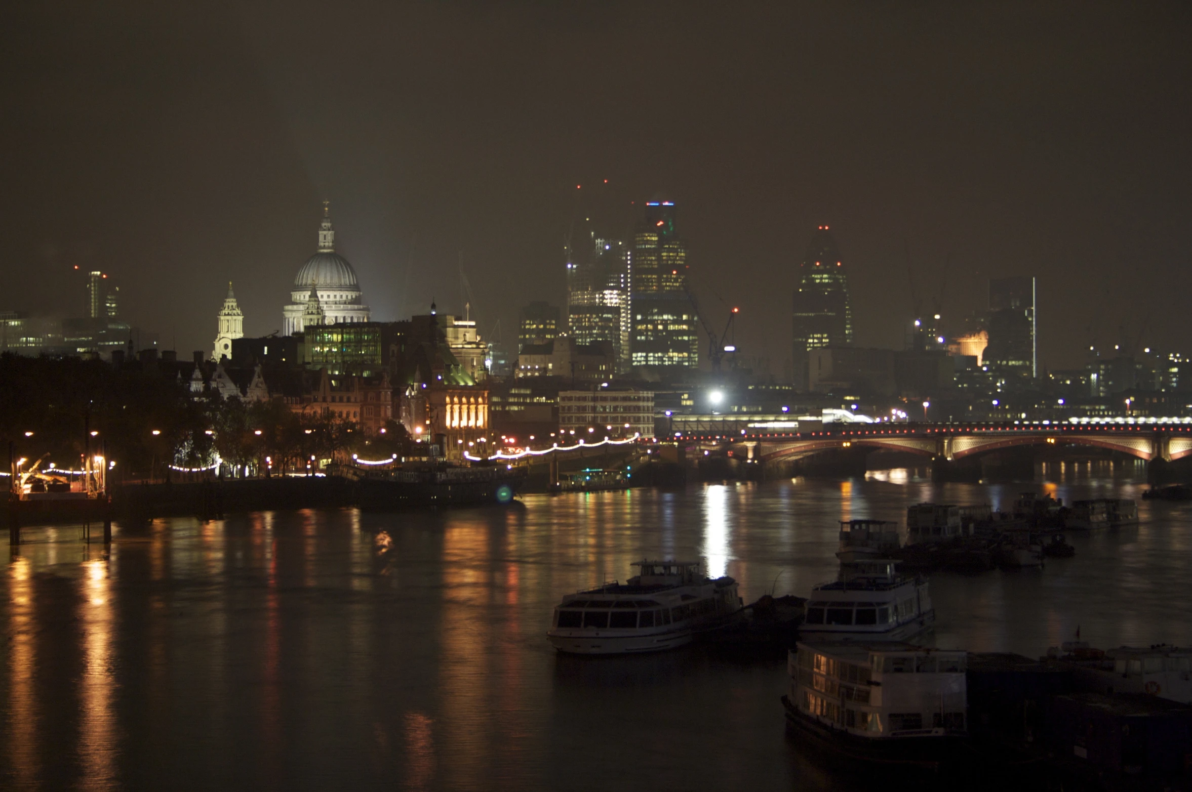 view of city lights reflecting on water at night