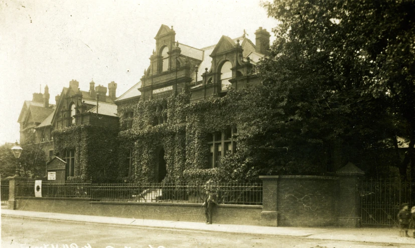 an old po of a large building covered in ivy