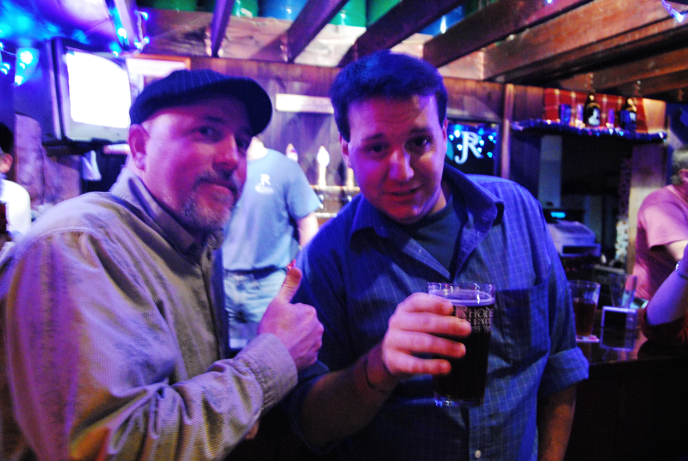 two men hold glasses of beer together