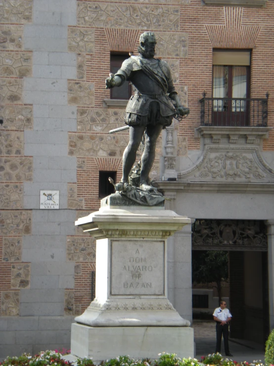 a man stands next to a statue in the courtyard of a building