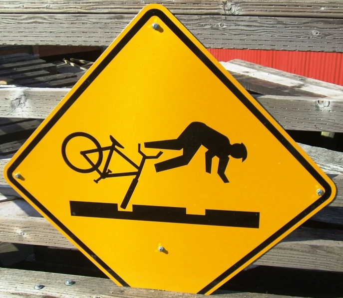 a caution sign with a person hing a bike