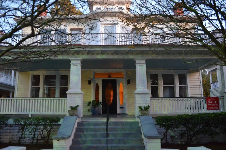 a building with white trim has stairs and trees