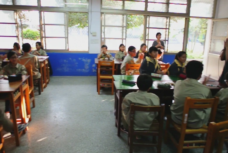 students and their teacher are sitting in chairs