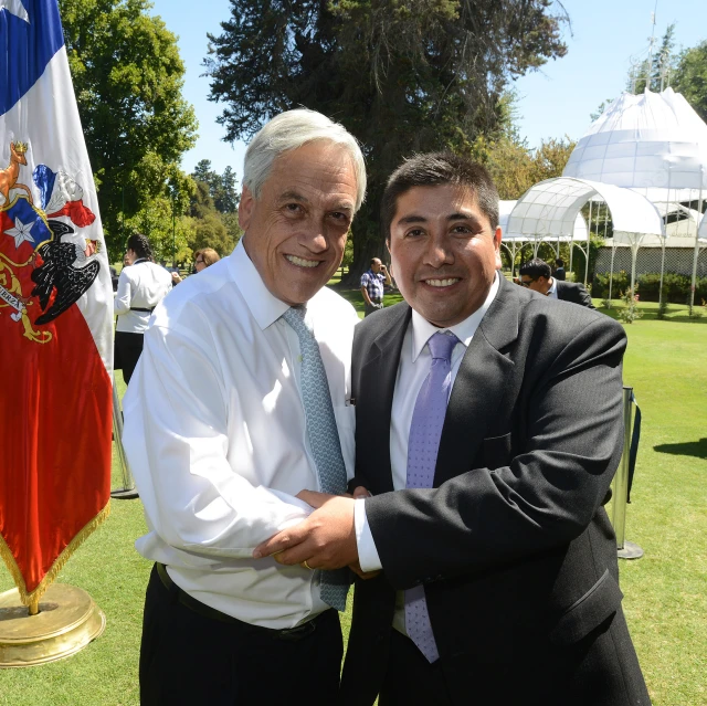 a man hugs another man at a stately gathering