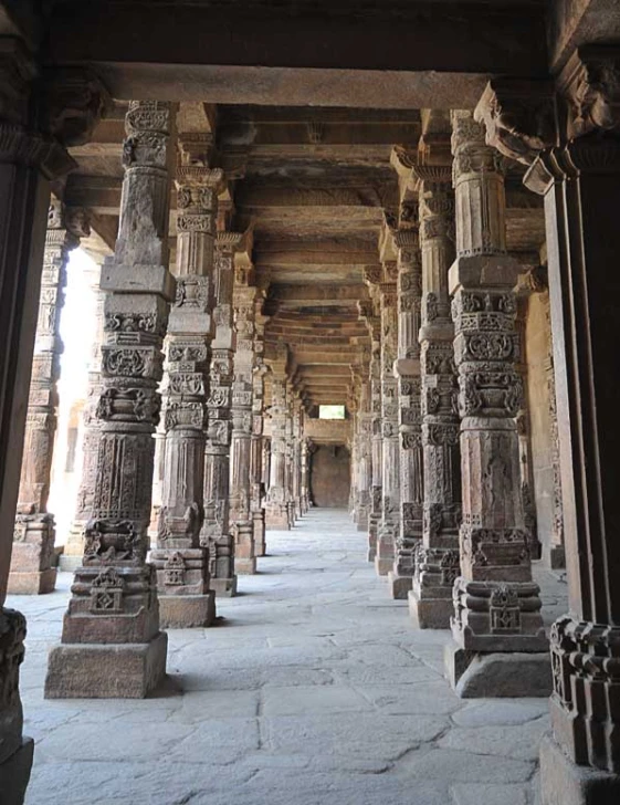 an old hallway with pillars and stone work on it