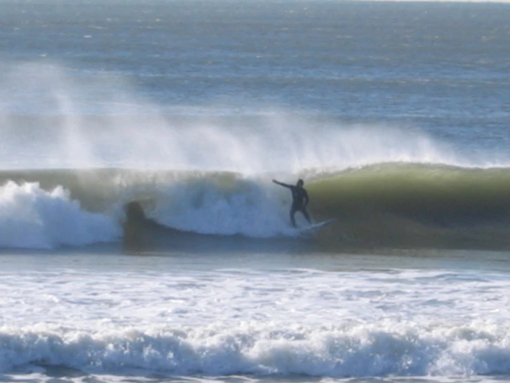 two people surfing at the beach on some waves