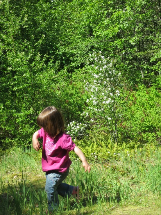 a girl is standing in some tall grass