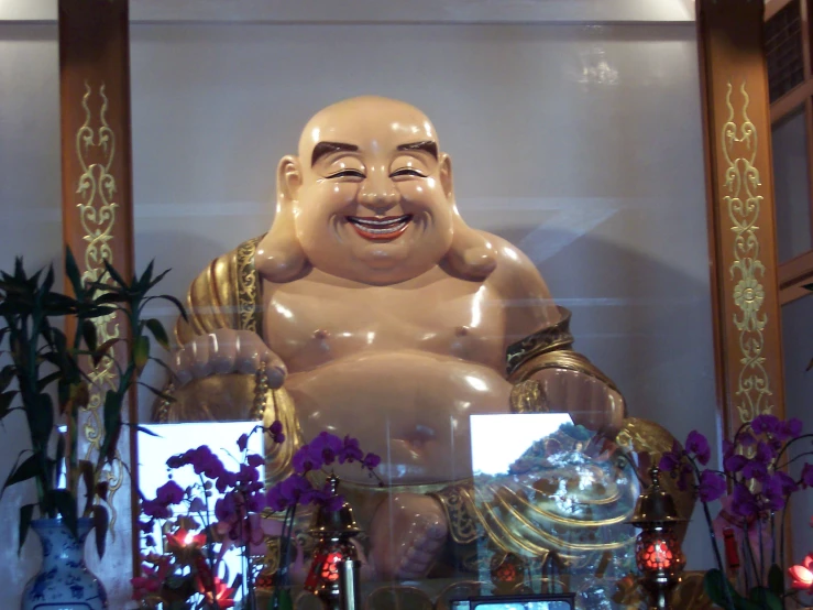 a statue of buddha with flowers in the front