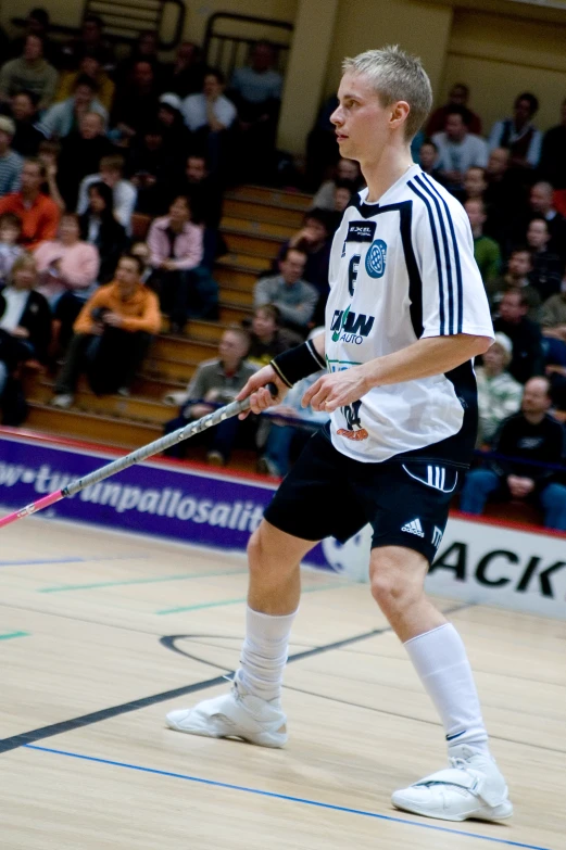 a man walking on a court holding a metal stick