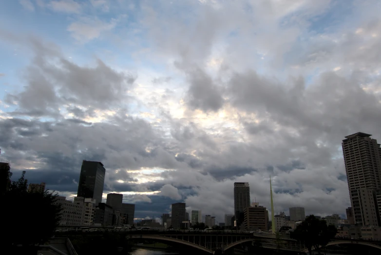 buildings and dark clouds hover above a river