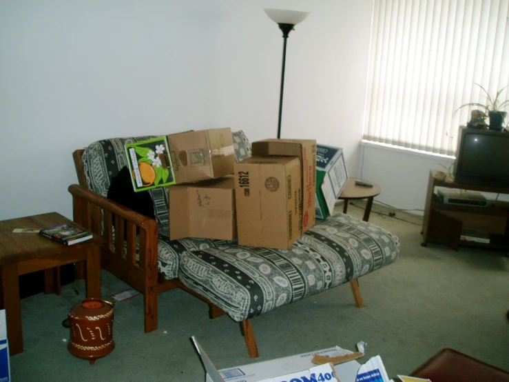 boxes on a couch in a room with no furniture