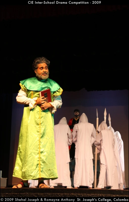a man in green robes with lots of ghost figures behind him