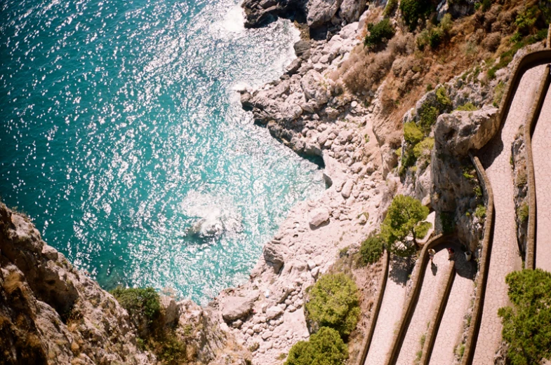 stairs leading to an ocean beach near rocky cliffs