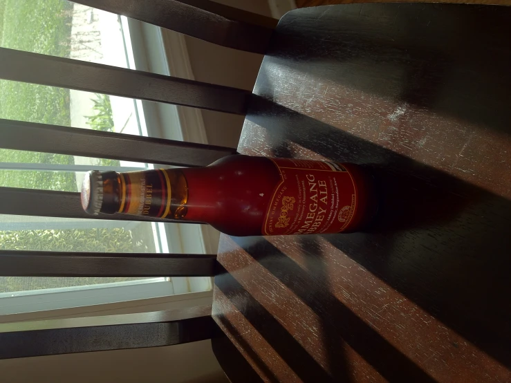 a brown table and wooden chair with a bottle on top of it