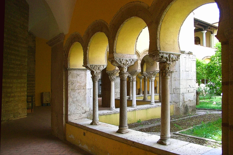 an arched wall with columns and benches