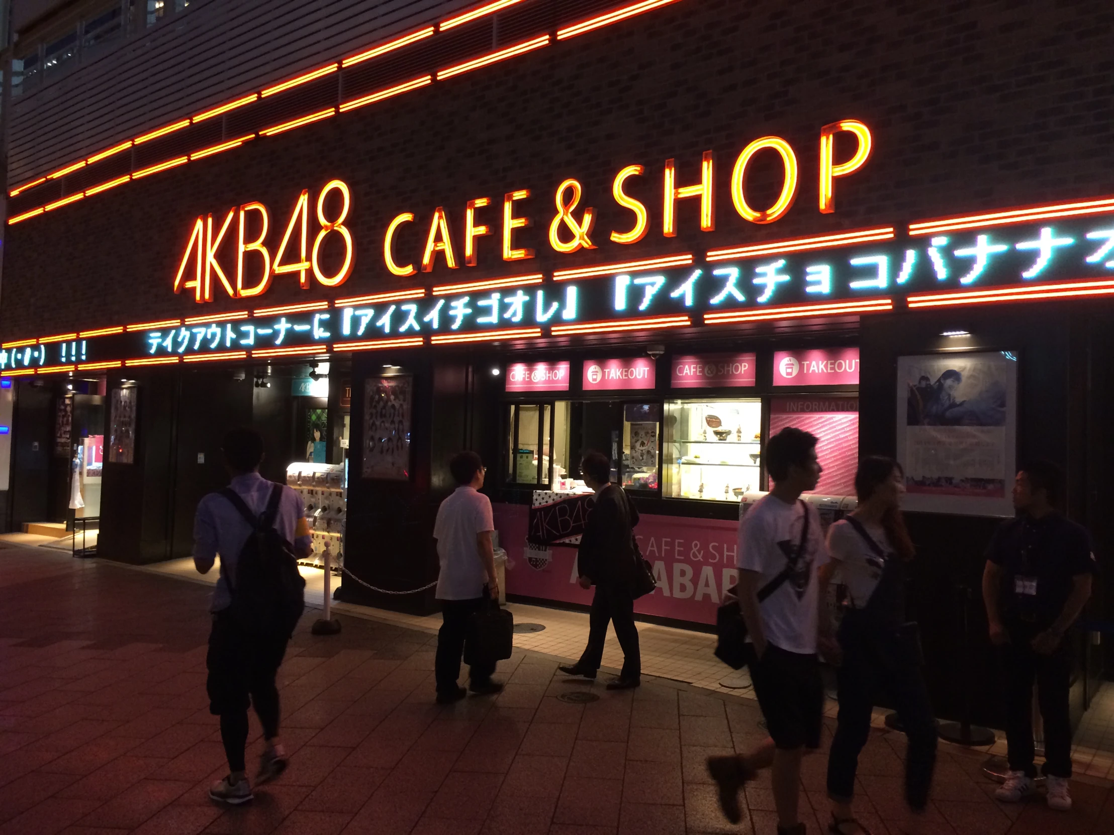 people standing outside a store with lights on