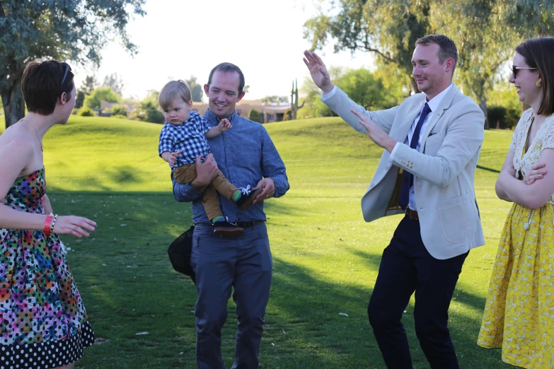 two men and a child standing in the grass