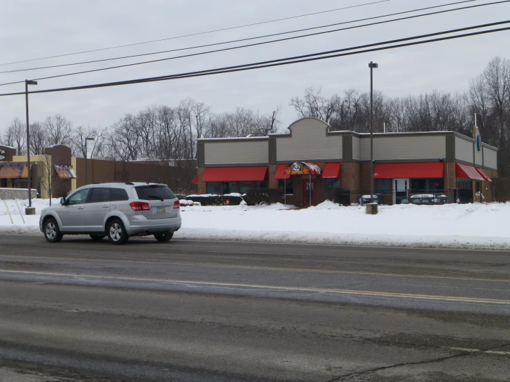 the grey truck is parked on the snow covered street