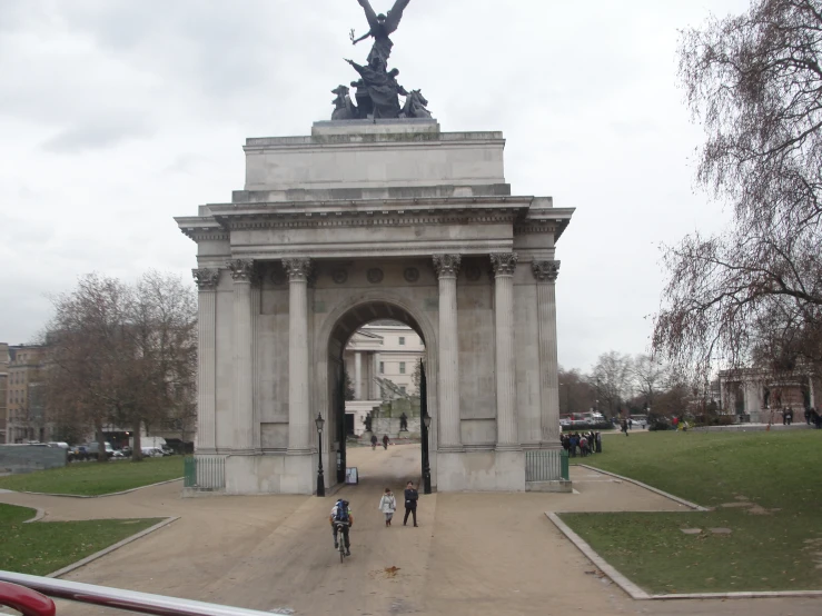 two people are riding bikes toward a large monument