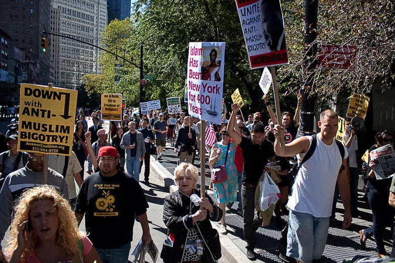 the people walk down the street together holding up signs