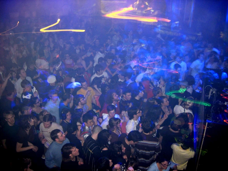 a big crowded nightclub with people standing in it