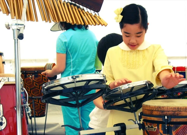 a child playing with two musical instruments on a stage